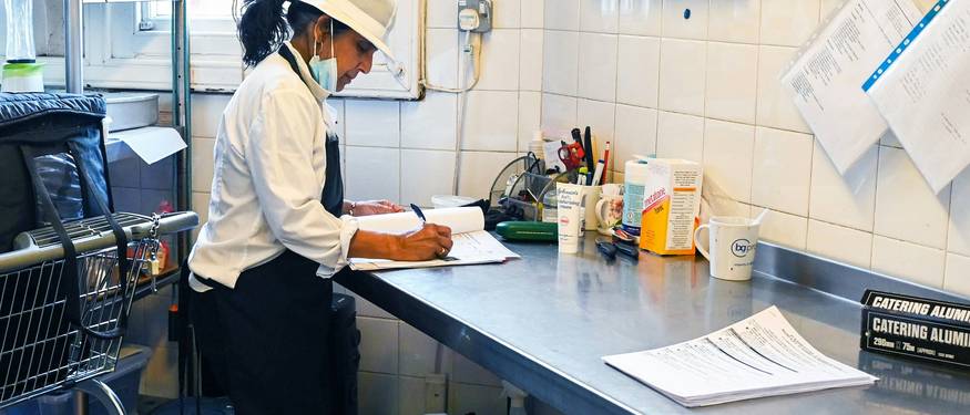 Ontario food inspector reviewing kitchen cleanliness and compliance during a workplace inspection