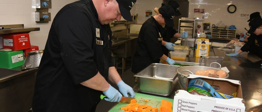 Ontario kitchen staff performing foodborne illness prevention procedures during a health inspection