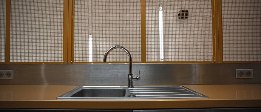 A spotless commercial kitchen in Ontario with visible handwashing sinks, food storage, and staff cleaning surfaces
